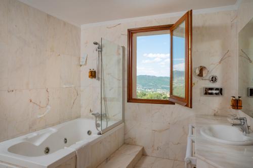 PeramolaHotel Can Boix de Peramola的带浴缸、水槽和窗户的浴室