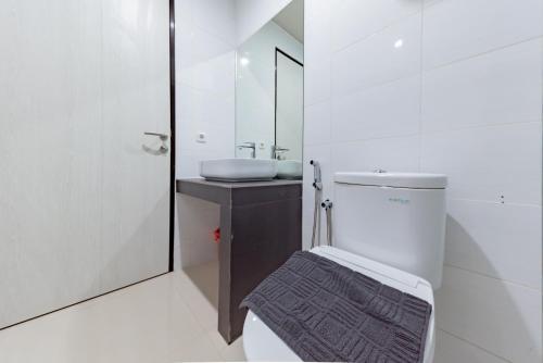 TanjungredepSans Hotel Berau Square的一间带水槽、卫生间和镜子的浴室
