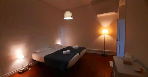 法鲁A Casa do Tenente的一间卧室配有一张带两个灯的床铺
