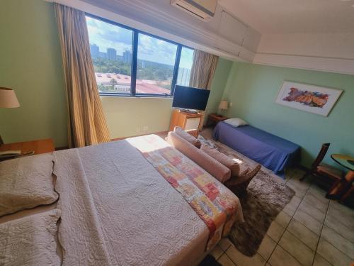 马瑙斯Tropical Executive Flat Vista Maravilhosa do Rio的一间卧室设有一张床和一个大窗户