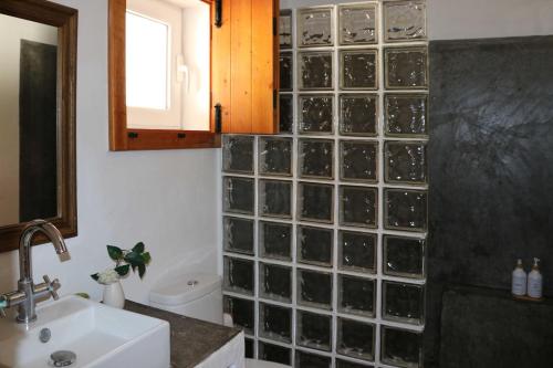 Vale de ÁguaMonte da Casa Nova - Jul and Ago only 7 days stays check-in and check-out on Saturdays的浴室设有玻璃墙、卫生间和水槽。