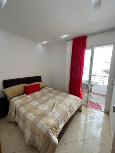 盖尼特拉Appartement de luxe, Tanagra Mall的一间卧室配有床和红色窗帘