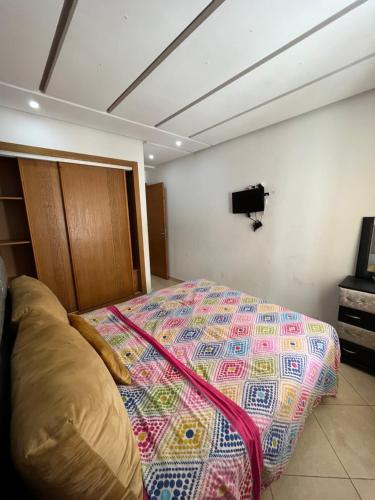 盖尼特拉Appartement de luxe, Tanagra Mall的卧室配有一张床,墙上配有电视。