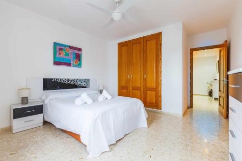 托雷德尔马尔Apartamento Azucarera Beach Torre del Mar的白色卧室配有床和吊扇