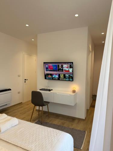 莱什Hotel Restaurant Natyra e Qetë的一间卧室配有书桌,墙上配有电视