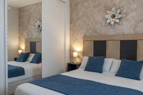 CarrascalejoCasa Rural La Posada del 42的酒店客房 - 带两张带蓝色枕头的床