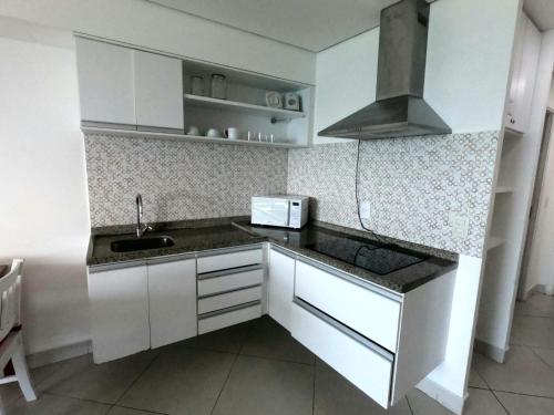 福塔莱萨Fortaleza VIP Experience的小厨房配有白色橱柜和水槽
