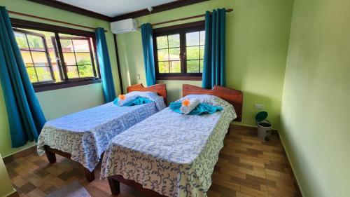拉迪格岛Lianita's Cottage (Selfcatering)的配有两张床铺的绿色墙壁和窗户