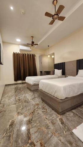 孟买Peace International的一间卧室配有两张床和吊扇
