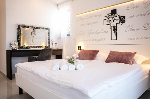 RebićiVilla Istra Relax Smaragd的卧室配有白色床,墙上有十字架