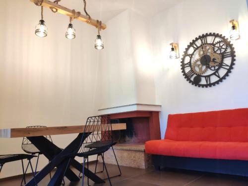 塞尔瓦迪法萨诺DaMami的客厅配有红色的沙发和时钟