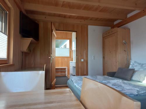 SchwarzachFerienwohnung in Schwarzach Vorarlberg的一间卧室配有一张床、一张桌子和一台电视