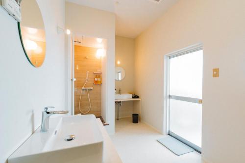 长崎长崎漫步之家旅馆的浴室配有白色水槽和淋浴。