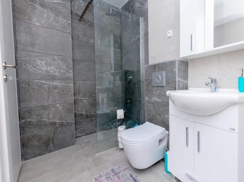 科尼茨Apartmani Jezero的带淋浴、卫生间和盥洗盆的浴室