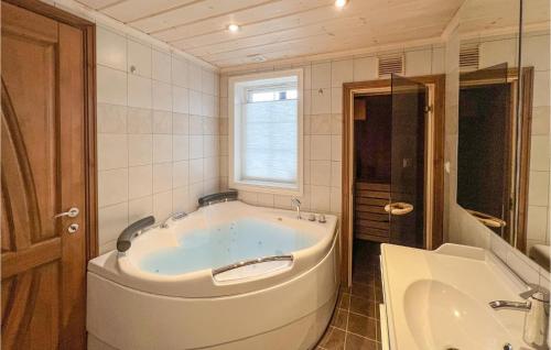 斯朱森Pet Friendly Home In Sjusjen With Sauna的一个带水槽的浴室内的白色大浴缸