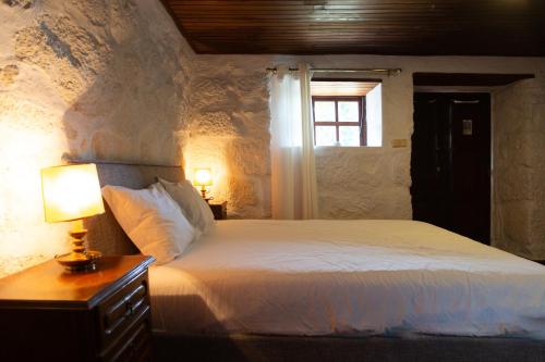 雷森迪Quinta da Graca- Complexo Turistico的一间卧室配有一张床和一张带台灯的桌子