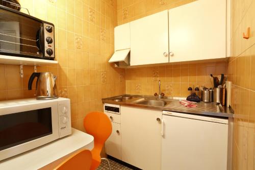 日内瓦托尔酒店的一间带水槽和微波炉的小厨房