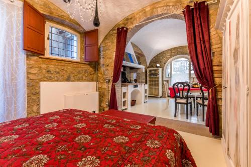 拉亚蒂科Lajatico Domus的一间带红色床的卧室和一间用餐室