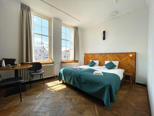 济里克泽Hector Zierikzee的卧室配有床、桌子和窗户。
