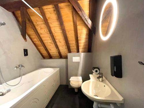 济里克泽Hector Zierikzee的浴室配有白色浴缸、卫生间和水槽。