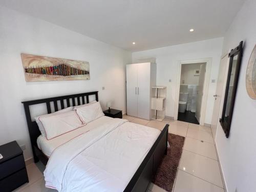 阿克拉‪Luxury One Bed Apt w/Balcony in Cantonment的一间卧室配有一张带白色床单的大床