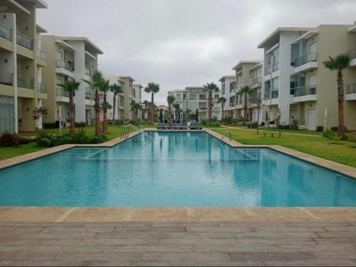 西迪拉哈尔Casabay appartement pied dans l'eau 87 m2的一座大型游泳池,位于部分公寓大楼前
