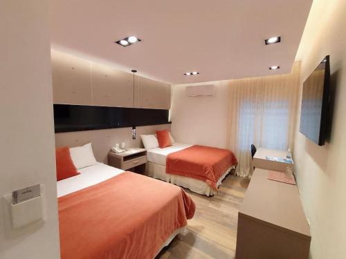 岑特纳里奥全球酒店 的酒店客房设有两张床和一台平面电视。