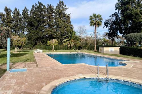 奎特里拉Casa das Mélias的一座大游泳池,位于一个树木繁茂的庭院内