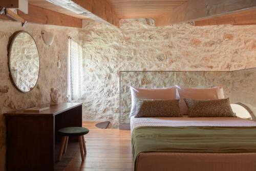 GállosMouria Country House的一间卧室配有一张大床和镜子