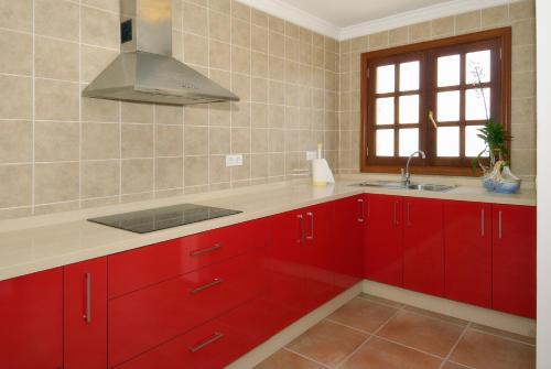 普拉亚布兰卡Apartment Limonade Deluxe Main Center Playa Blanca By PVL的一间带红色橱柜和水槽的厨房