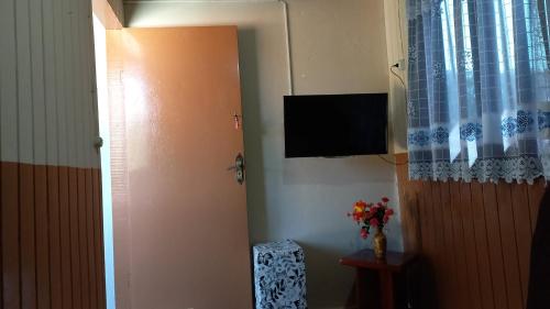 坎波斯杜若尔当Casa Recanto的墙上配有平面电视的房间