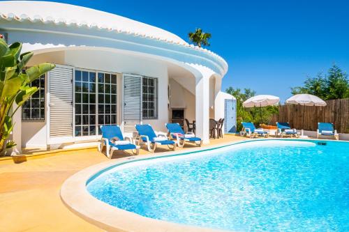 阿玛考德佩拉Villa Menorca by Algarve Vacation的一个带椅子的游泳池以及一座房子