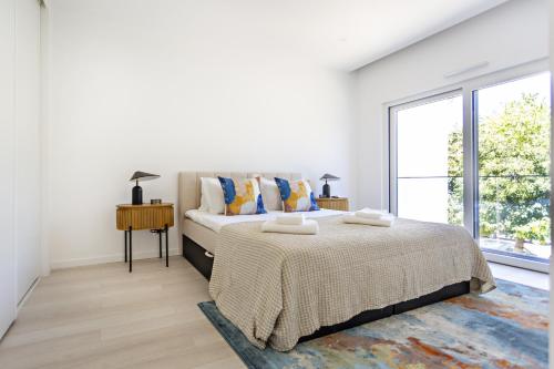 塔维拉Special Cabanas的白色的卧室设有床和大窗户