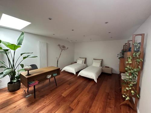 奈梅亨Studio Senang的客厅设有两张床,铺有木地板。