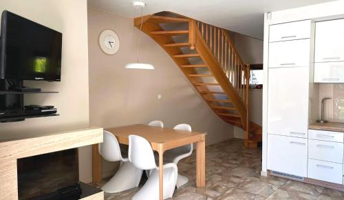 波别罗沃Apartament Pobierowo的一间带木桌和楼梯的用餐室