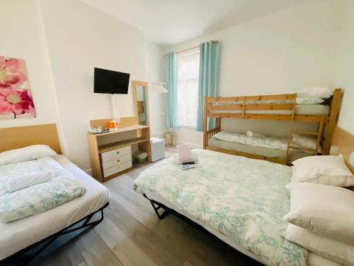 布莱克浦格兰维尔酒店的一间卧室配有两张床和一张双层床。