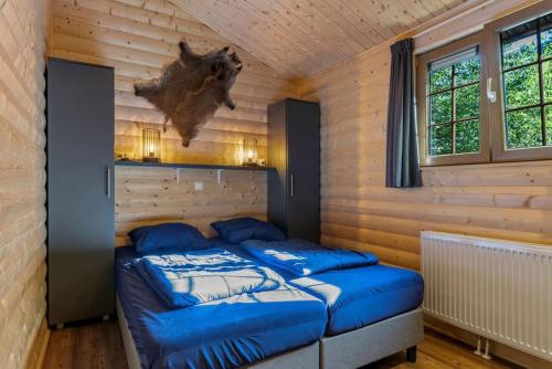 奥特罗De Blije Wereld的配有木墙和窗户的客房内的两张床
