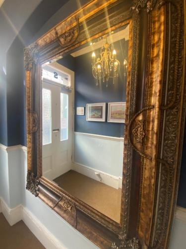 布莱顿霍夫Blue Sky Guest House的吊灯房间的大镜子