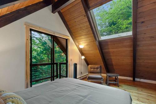 贝灵厄姆Bellingham A-Frame - Hot tub & Firepit的一间卧室设有一张床和一个大窗户