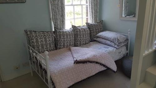 温彻斯特Millstream House的卧室配有带枕头的床铺和窗户。