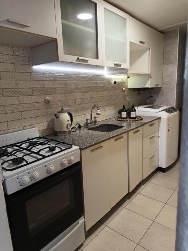 圣米格尔·德·图库玛HERMOSO DPTO 2 dor TUCUMAN的厨房配有白色橱柜和炉灶烤箱。