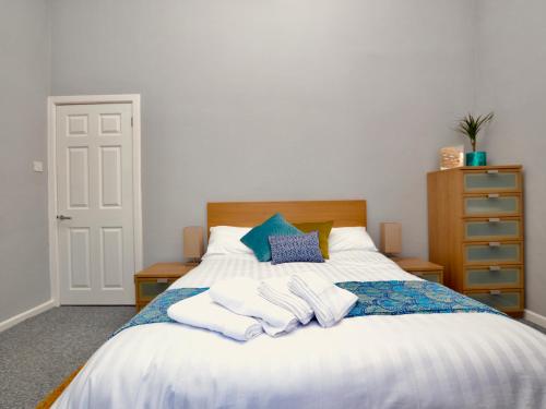切尔滕纳姆Stephen's Cheltenham apartment的一间卧室配有带毛巾的床