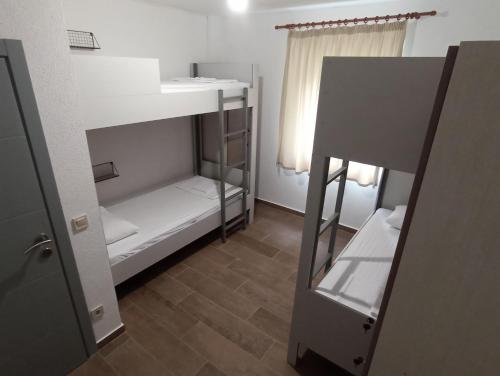 巴尔Hostel Hangout的小房间设有两张双层床和窗户