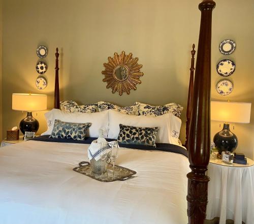 萨默维尔Flowertown Bed and Breakfast的一间卧室配有一张带白色和蓝色枕头的大床