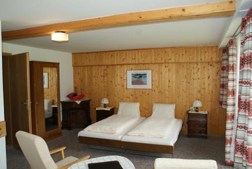 坎德施泰格斯派切尔膳食公寓酒店的一间卧室设有一张床和木墙