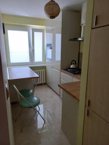 比得哥什Apartament 7 Piętro的厨房配有桌子和绿色椅子