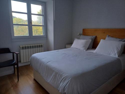 埃利松多Aritza Apartamentos Turísticos Rurales的卧室设有一张白色大床和一扇窗户。