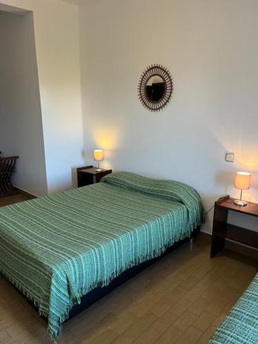 蒙希克Miradouro da Serra的一间卧室配有绿床、两张桌子和镜子