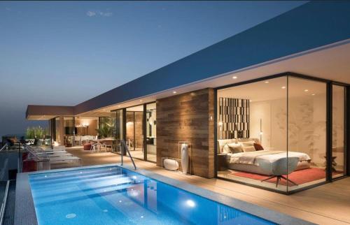 阿德耶Luxury Villa Rebeka - Heated Pool and Jacuzzi的一间卧室和一个房子内的游泳池