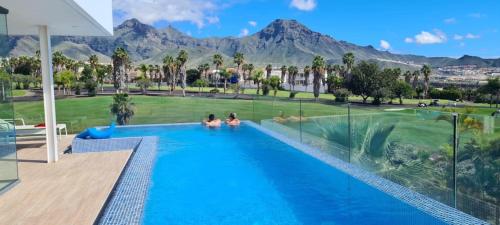 阿德耶Luxury Villa Rebeka - Heated Pool and Jacuzzi的两人坐在一个山地游泳池里